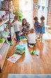 © Krakenimages.com - Beautiful teacher and group of toddlers playing around lots of toys at kindergarten