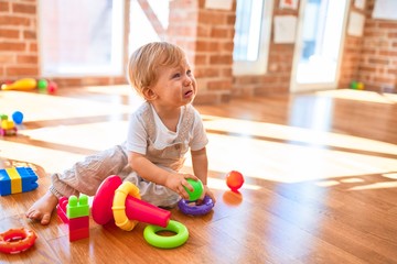 Poster - Adorable blonde toddler crying around lots toys at kindergarten