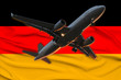 airplane on the background of the silk national flag of the modern state of Germany with beautiful folds, the concept of tourism, economy, politics, emigration, globalization