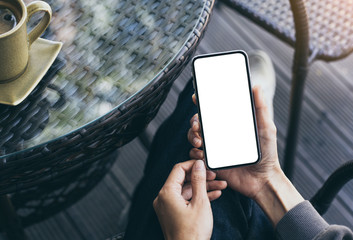 Mockup image blank white screen cell phone.woman hand holding texting using mobile on desk at coffee shop.background empty space for advertise text.people contact marketing business,technology