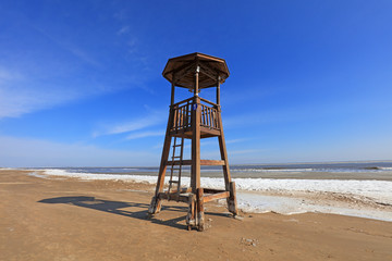 Canvas Print - Watchtower on the sea, snow in the blue sky