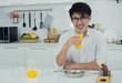 © Ann Rodchua - An asian man is drinking orange juice
