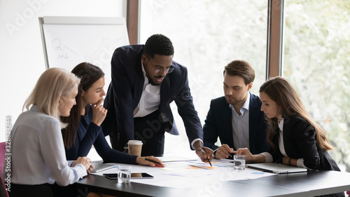 Fotografía Confident african American male boss work cooperate with diverse team at office