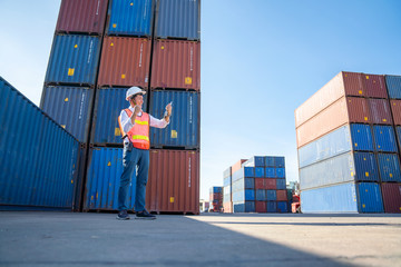 Logistics engineer control at the port, loading containers for trucks  export and importing logistic concept