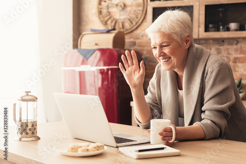 Cuadros en Lienzo Elderly woman making video call on laptop in kitchen