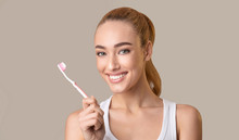 Happy Woman Holding Toothbrush Smiling At Camera Posing, Studio Shot