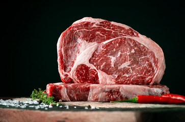 Wall Mural - Raw rib eye beef steak on a black background