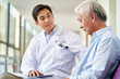 © imtmphoto - young asian doctor explaining test result and diagnosis to senior man in hospital hallway