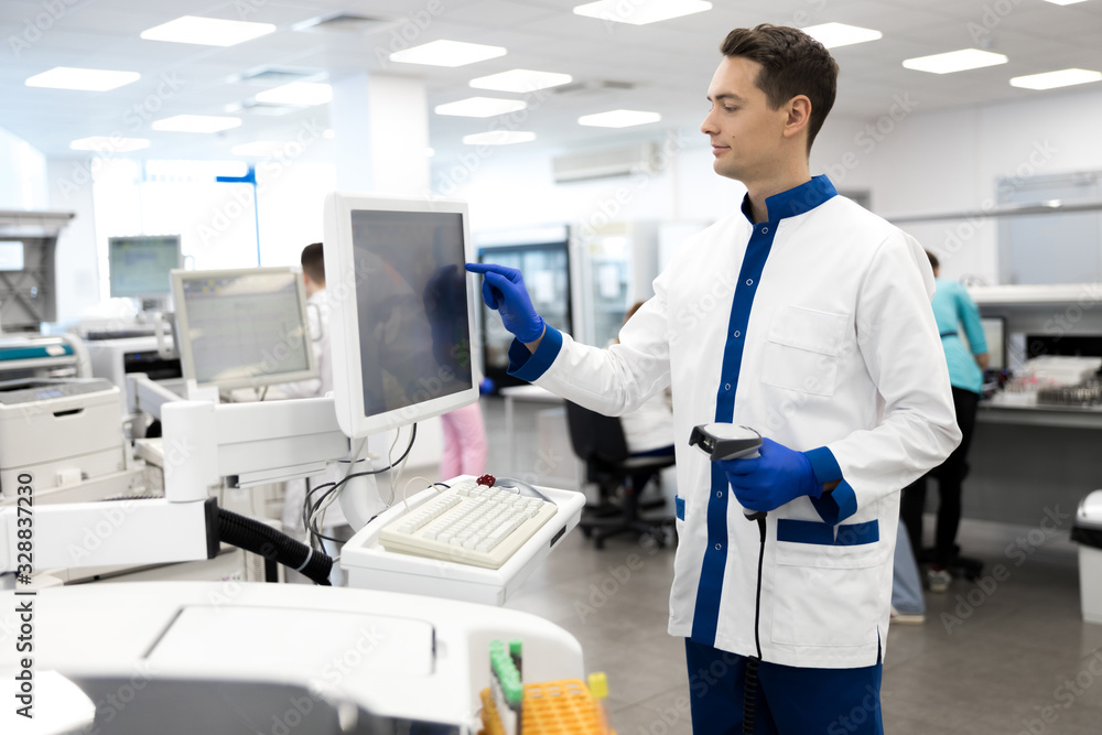 Young male scientist using lab machine for pathology blood test Stock ...
