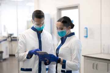 Laboratory workers using digital tablet in clinic