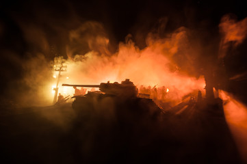 War Concept. Armored vehicle silhouette fighting scene on war foggy sky background at night.