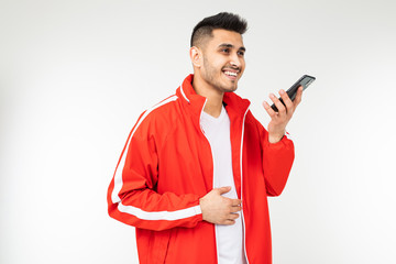 man in sportswear in red talks on the phone on a white background