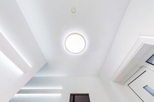Suspended Ceiling With Halogen Spots Lamps And Drywall Construction In Empty Room In Apartment Or House. Stretch Ceiling White And Complex Shape.