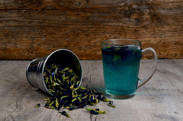 Cup of Butterfly pea flower tea and dried flowers on a gray background. view from the top