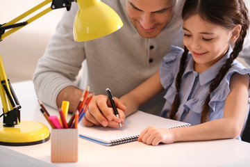 Sticker - Man helping his daughter with homework at table indoors