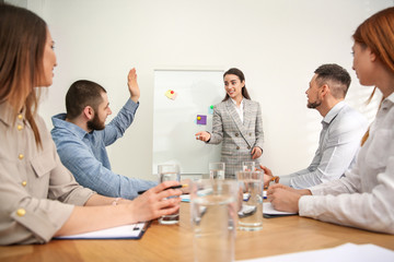 Wall Mural - Man raising hand to ask question at business training in conference room