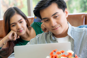 Young couple use credit card for online shopping on internet website at home. Number on the credit card is mock up. No personal information shown on the credit card. Online business shopping concept.