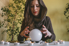 Young Mysterious Woman Holds Her Hands Over A Crystal Ball Of Predictions