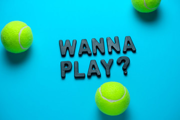 top view flat lay tennis balls and inscription wanna play on a bright blue background