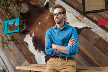 Wall Mural - Hopeful model looking away, smiling with his arms crossed