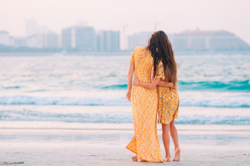 Beautiful mother and daughter at the beach enjoying summer vacation.