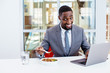 © Carlos David - Portrait of a happy smiling young man in business suit eating lunch at work at his desk with laptop computer in his office