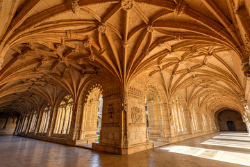 Wall Mural - Lisbon, Portugal - September 10, 2019: Ornamental and empty cloister at the historic Manueline style Mosteiro dos Jeronimos (Jeronimos Monastery) in Belem, Lisbon, Portugal, on a sunny day.