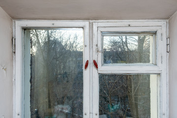 An old vintage wooden window with peeling paint oh frames needed to be repaired or replaced