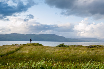 Wall Mural - Tourist at Island of Mull eastern cape. Beautiful scottish nature at sunset light. Duart castle hill, Scotland.