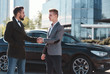 © Fxquadro - Young and handsome businessmen shaking hands standing outside near black car, wearing luxury clothes and making a deal
