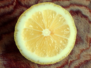 A round slice of lemon on a brown wooden Board