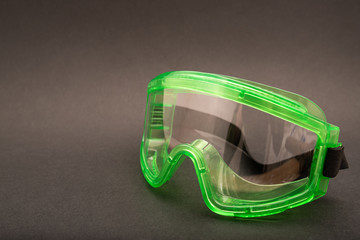 green safety glasses on black background