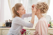 © Miramiska - Makeup artist, hair professional stylist makes young beautiful bride bridal makeup before wedding in a morning