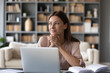 © fizkes - Head shot young dreamy woman sitting at table, distracted from computer work. Lost in thoughts lady looking away, planning visualizing future at home. Entrepreneur enjoying break pause time.