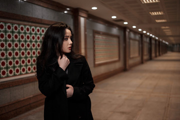 Wall Mural - a young beautiful woman walks through an underground passage at night, looking back with fear.mosaics on the walls are not paintings, not someone's works of art. it's just walls in eastern style.  