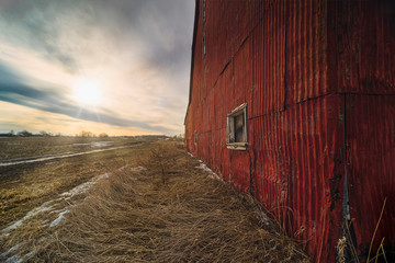 Wall Mural - stunning dramatic sunsets in rural farm country with barns and cold fields with rainbow.