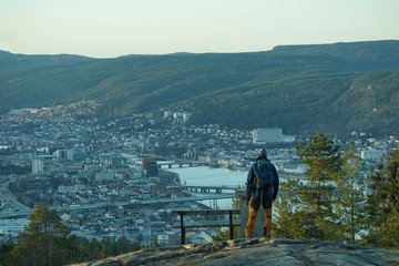 Standing on a mountain and looking at the city down.