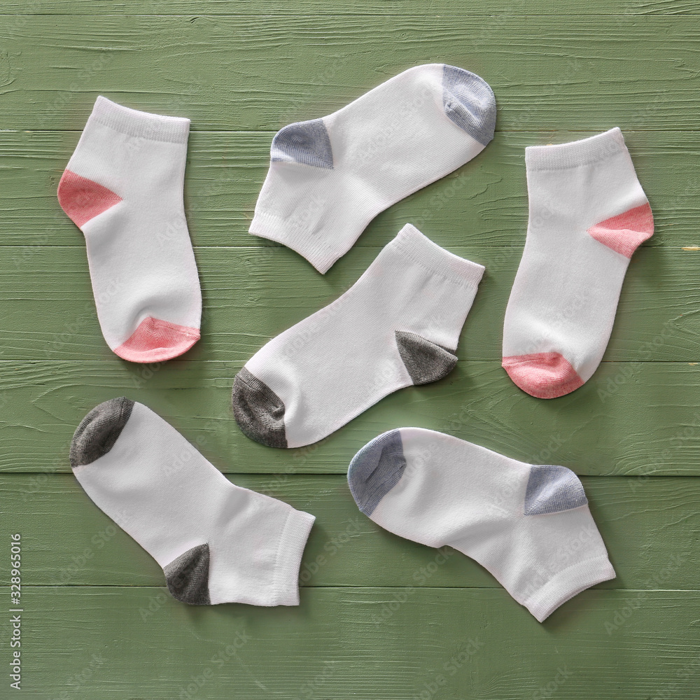 Different cotton socks on color wooden background