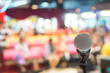 © Apichet - Microphone over the Abstract blurred of speech in seminar room or conference hall light in exhibition center background, business and education concept.