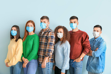 Wall Mural - Group of people with protective masks on light background. Concept of epidemic