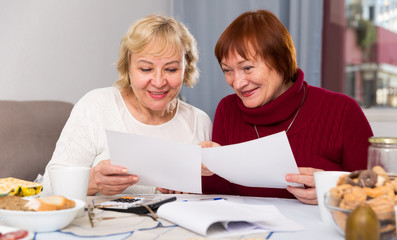 Two positive mature women with papers