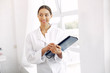 © prostooleh - Lady in a uniform. Doctor on a white background. Woman hold a folder in her hands.