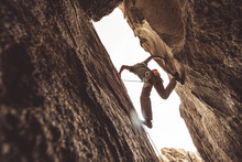 Rock Climber In A Canyon, Pressing Between Two Walls.