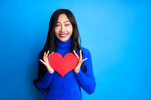Pretty Young Woman Holding Big Paper Heart In Her Hands Isolated On Blue Background
