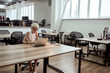 © Svitlana - Too much work. Young and busy tattooed businesswoman in eyeglasses working with laptop while sitting alone at her desk in the modern office