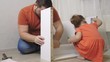© Евгения Медведева - daughter with dad assemble white furniture together. Close up.