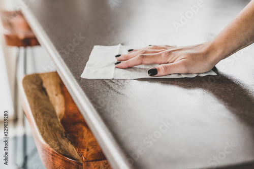 Fotografía disinfecting surfaces from bacteria or viruses, hand cleaning bar table with dis