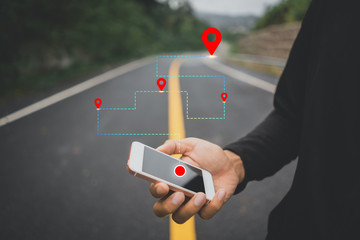 Wall Mural - Man hand using smartphone with gps navigator map icon on blur street background.