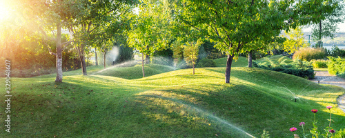 Fotomural Landscape automatic garden watering system with different sprinklers installed under turf