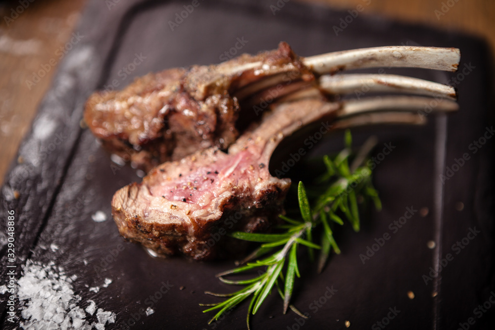 Grilled lamb chops served with a branch of rosemary - obrazy, fototapety, plakaty 